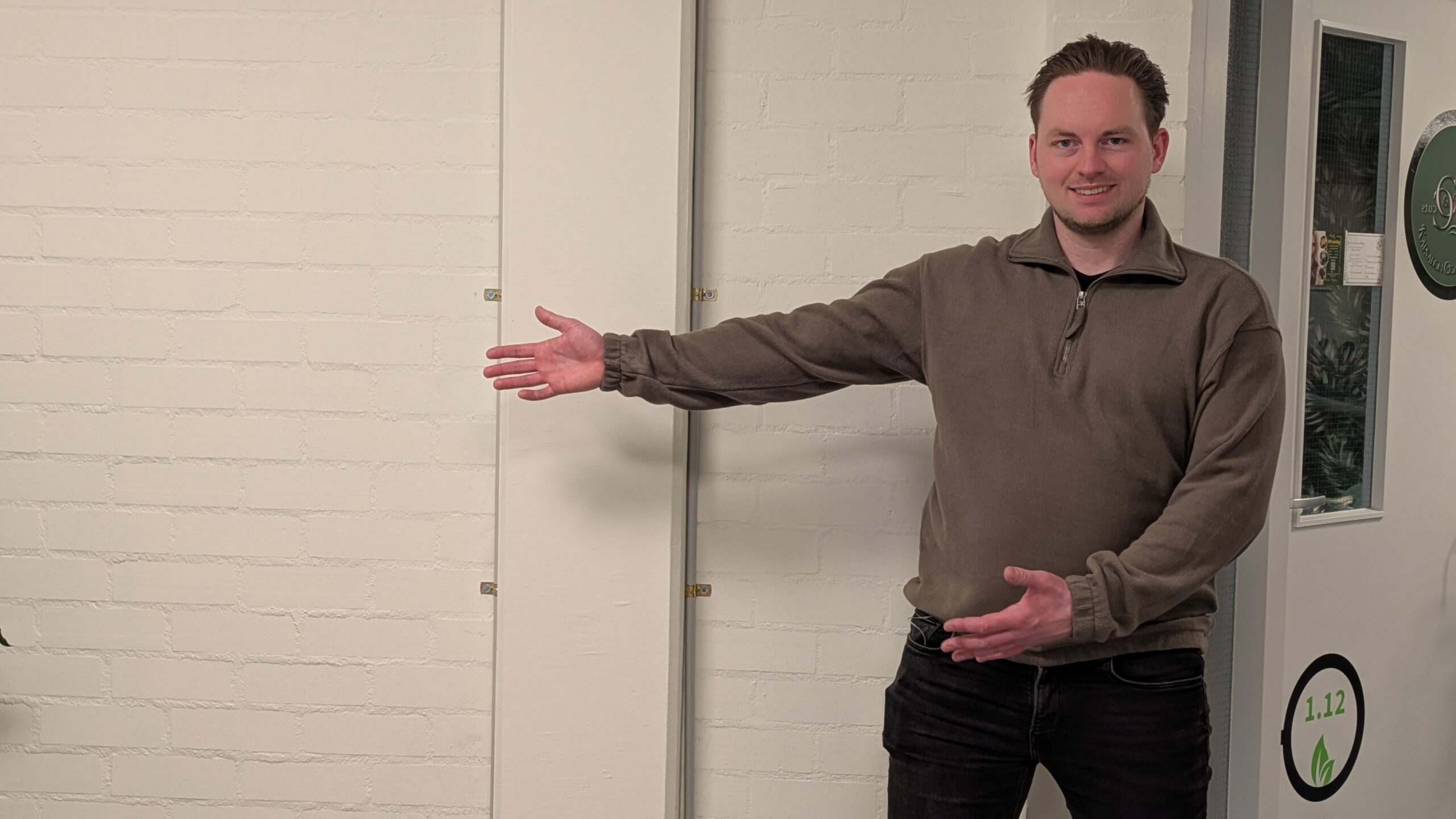 Belegger Kees wijst naar links en kijkt richting uitleg over beleggen